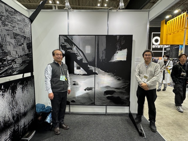 シーピープラス2024で展示中の金属パネル刻鈑の前で写真家萩原義弘氏と共に